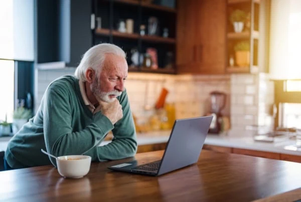 senior man breakfast kitchen cereal laptop 1200