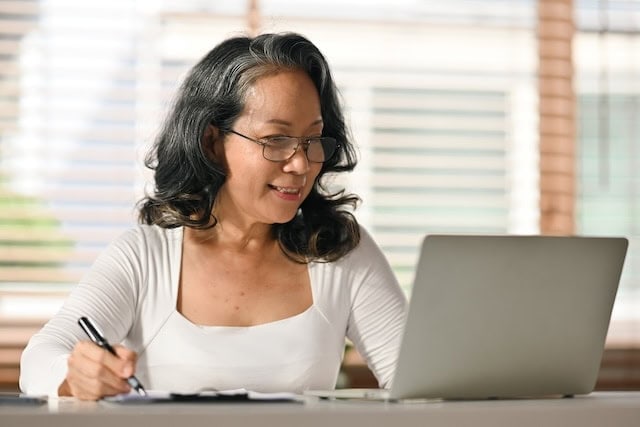 smiling senior woman looking at laptop 640