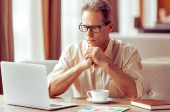 thinking retirement over laptop coffee 1200