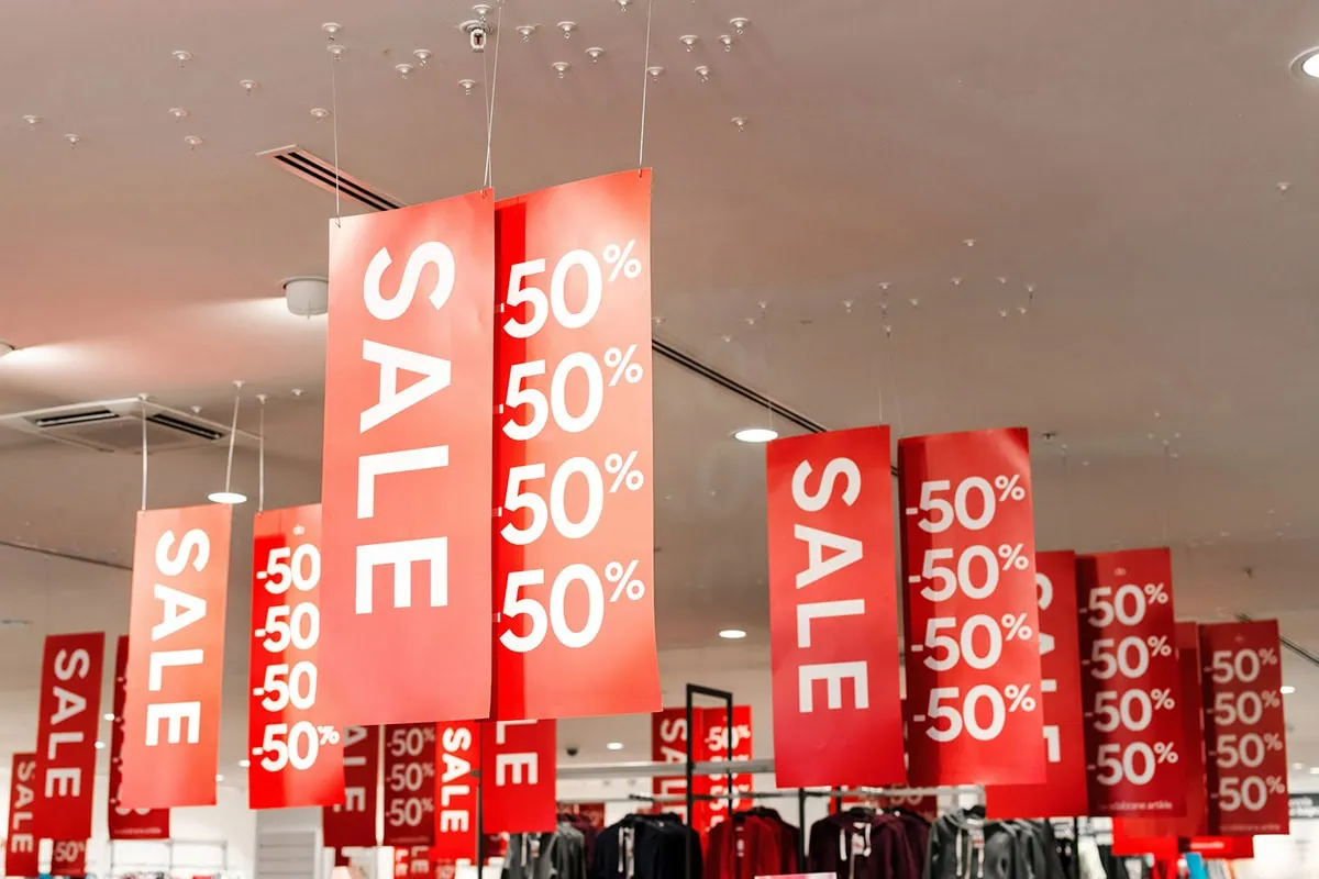 7 Best Value Stocks to Buy Right Now 2 a number of large sale sign banners hanging from the ceiling.