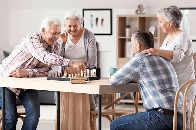 residents of a senior housing building play chess.