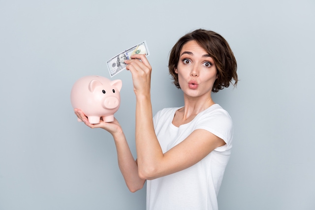 woman placing money in a piggy bank