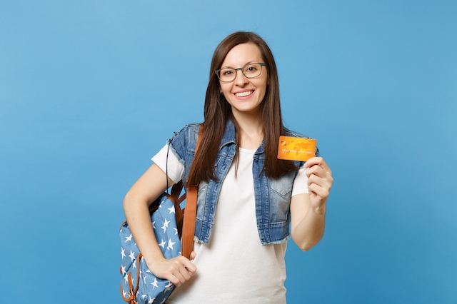 young woman blue background debit credit card